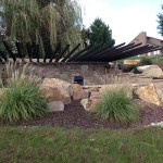 Custom stonework in garden with long wooden stakes